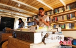 9月5日，海南三亚西岛渔村“海上书房”，桌上传统装鱼的盆被用来放书，年轻人在翻看书籍。　尹海明 摄 - 中新网海南频道