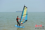 游客在海口市国家帆船帆板基地体验帆板冲浪。见习记者 王程龙 - 中新网海南频道