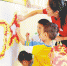 10月8日，在澄迈县福山中心幼儿园，一名教师指导孩子们用彩纸制作庆祝新中国成立70周年图案。 本报记者 苏晓杰 通讯员 王家专 摄 - 中新网海南频道