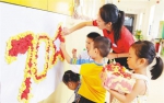 10月8日，在澄迈县福山中心幼儿园，一名教师指导孩子们用彩纸制作庆祝新中国成立70周年图案。 本报记者 苏晓杰 通讯员 王家专 摄 - 中新网海南频道