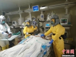 负压病房医护人员在床边为危重型新冠肺炎患者做纤维支气管镜。 海南省人民医院供图 - 中新网海南频道
