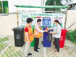 儋州市分类生活垃圾定时投放点，2名志愿劝导员引导市民正确分类垃圾。通讯员 罗鑫 摄 - 中新网海南频道
