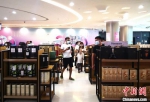 图为8月26日游客在三亚国际免税城内选购酒类商品。　尹海明 摄 - 中新网海南频道