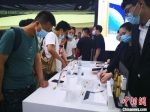 图为8月26日游客在三亚国际免税城内选购电子产品。　尹海明 摄 - 中新网海南频道