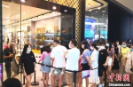 图为8月26日游客在三亚国际免税城内排队进店购物。　尹海明 摄 - 中新网海南频道