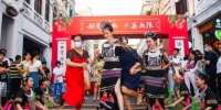 在海口骑楼老街，身穿黎族服饰的舞蹈演员正在和市民游客一起跳海南民俗特色竹竿舞。 记者 康登淋 摄 - 中新网海南频道