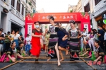 在海口骑楼老街，身穿黎族服饰的舞蹈演员正在和市民游客一起跳海南民俗特色竹竿舞。 记者 康登淋 摄 - 中新网海南频道