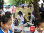 暴雨致海口一学校门口积水 医院保安用船送学生入校 - 中新网海南频道