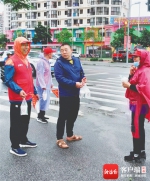 市民给张世青(左一)等队员送雨衣和豆浆。 (东方市新东方人志愿服务党支部供图) - 中新网海南频道