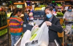 11月18日，海口旺豪超市收银台工作人员使用可降解环保袋为顾客打包商品。海口日报记者 康登淋 摄 - 中新网海南频道