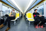 12月22日，乘客搭乘“水菜花”号市域列车返回市区。康登淋 摄 - 中新网海南频道