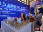 现场展出的部分海水稻产品。图中玻璃瓶中装的是海水稻米酒。　记者王晓斌 摄 - 中新网海南频道