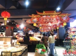 超市挂上大红灯笼和喜庆的生肖展牌，营造喜庆的新年氛围。陈家煜 摄 - 中新网海南频道