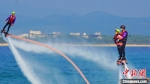 游客在三亚蜈支洲岛体验水上飞人。　陈宏 摄 - 中新网海南频道