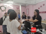 小林和爱人接过工作人员递上的结婚证书。记者韩星 摄 - 中新网海南频道