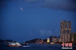 5月26日傍晚，香港市民在黄埔海滨观赏“超级月全食” ，食甚期间月亮呈现暗红色，吸引大量市民前来欣赏。图为“超级满月”升至半空。　 中新社记者 李志华 摄 - 中新网海南频道