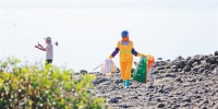 　在洋浦经济开发区新英湾海滩上，环卫工人在清理垃圾。记者 陈元才 摄 - 中新网海南频道