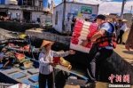 海南省公安厅海岸警察总队第七支队民警帮渔民搬箱子。　孙健 摄 - 中新网海南频道