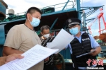 海南省公安厅海岸警察总队第四支队民警向渔民宣传防疫知识。　张春来 摄 - 中新网海南频道