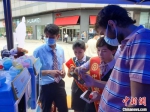 工作人员协助在三亚工作外籍人士开通数字人民币钱包。　王晓斌 摄 - 中新网海南频道