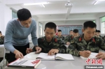 辅导老师正在为备考战士解答学科中的难题。　武警海南总队机动支队供图 - 中新网海南频道