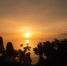 游客在海边与夕阳美景合影。　凌楠 摄 - 中新网海南频道