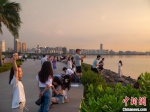 在海边拍摄夕阳美景的游客。　凌楠 摄 - 中新网海南频道