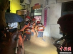 消防救援人员转移疏散被困群众。　莫文彬 摄 - 中新网海南频道