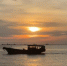 夕阳下，一艘渔船缓缓驶过水面。　张月和 摄 - 中新网海南频道