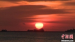 一轮红日悬浮在海口湾海面之上。　张月和 摄 - 中新网海南频道