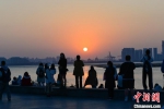 12月23日，市民游客在海口湾观赏落日美景。　凌楠 摄 - 中新网海南频道