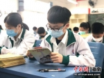 学生认真阅读《总体国家安全观(海南省学生读本)宣传手册》。闻轩 摄 - 中新网海南频道